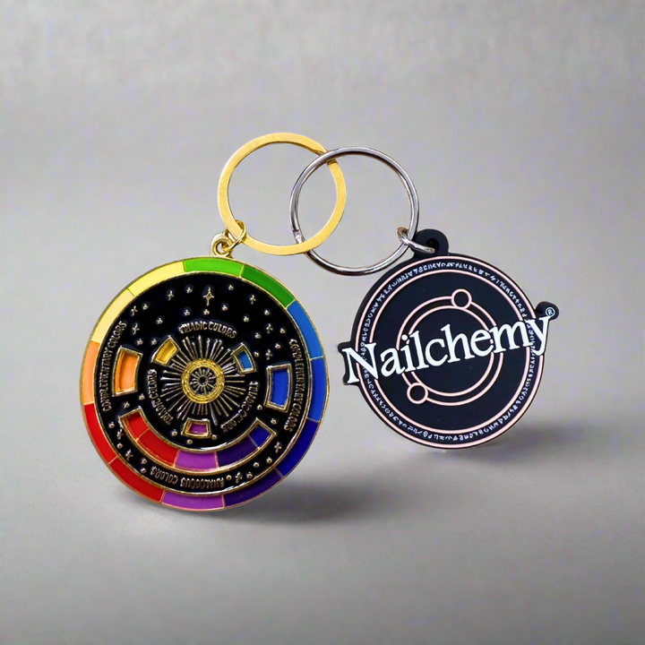 Colorful circular keychain with 'Nailchemy' logo on a white background
